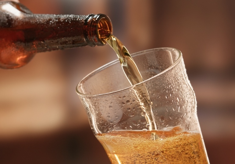 Beer being poured from a bottle into a mug