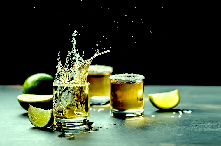 Shot glasses of tequila and lime on a table