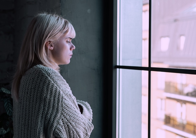 Woman near the window reflecting on the past