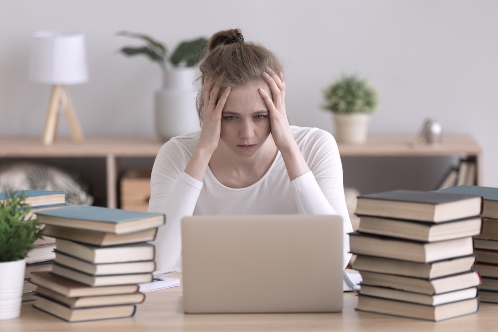 Male student slumped on a book trying to concentrate