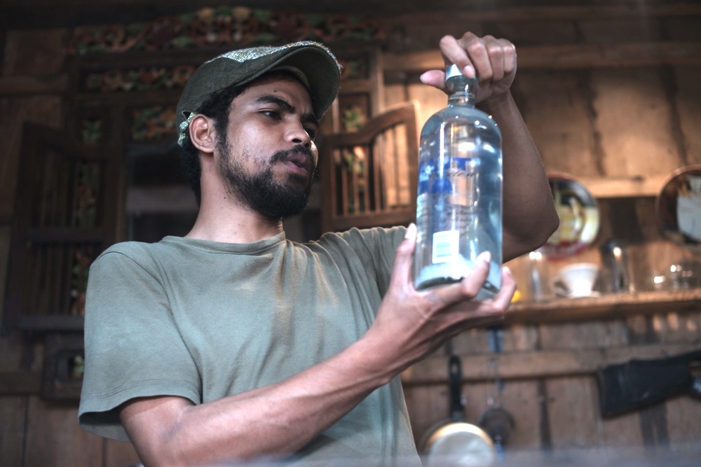Man checking out an old bottle of vodka, he is not sure if expired