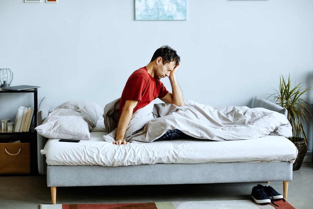 A man with a hangover woke up from sleeping on the couch 
