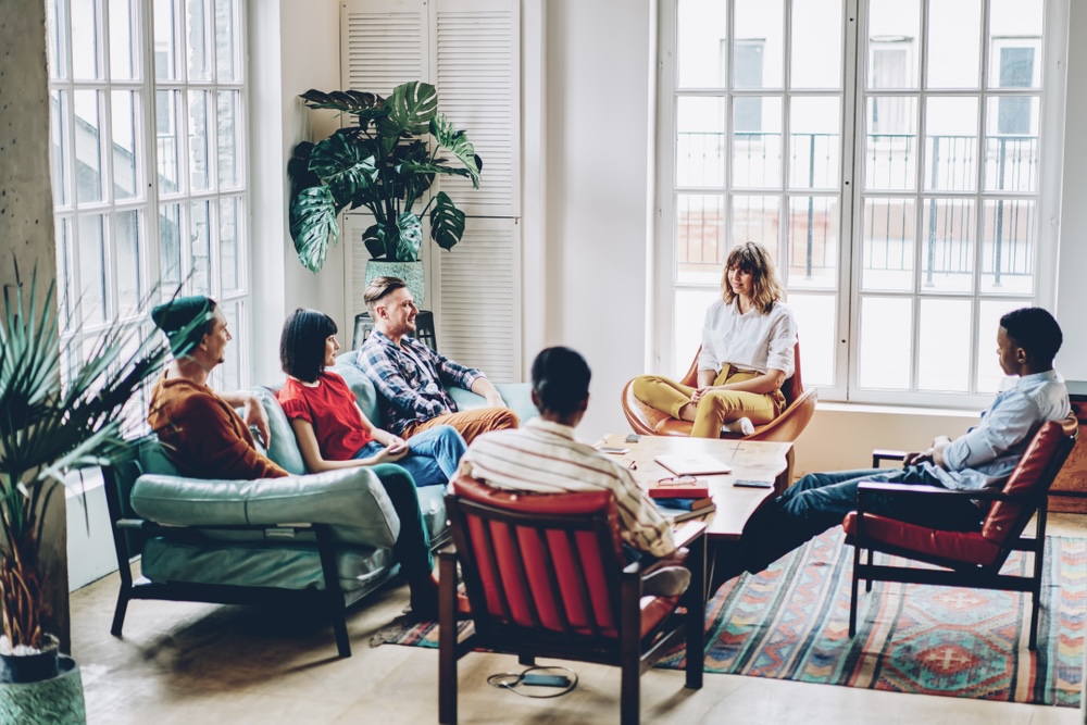 Group of men and women in group therapy who live in sober housing