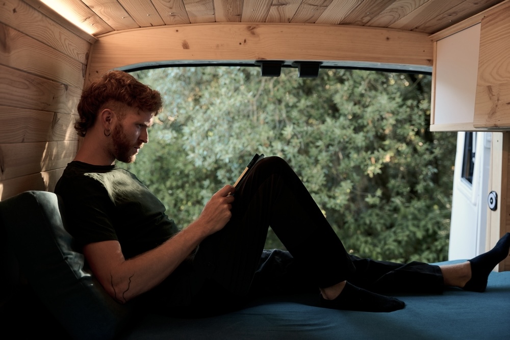 Man in a camper van reading inspiration, getting sober quotes