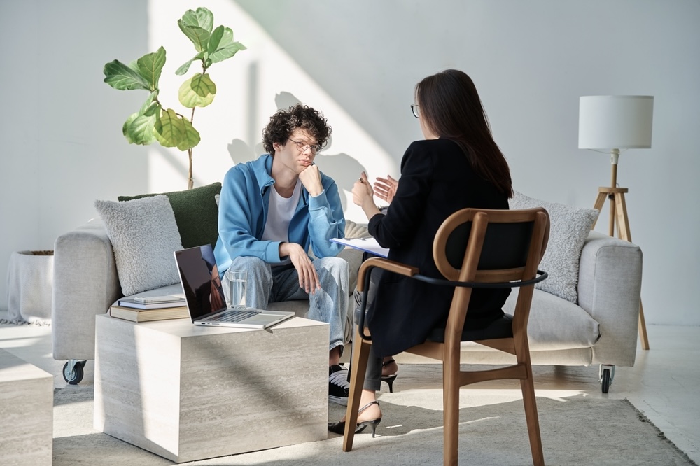 Adult male speaking to an addiction specialist in rehab